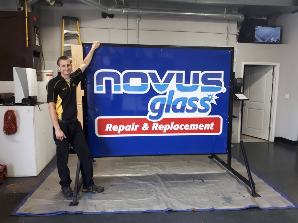 Shelby with the new NOVUS Glass Sarnia Road sign.