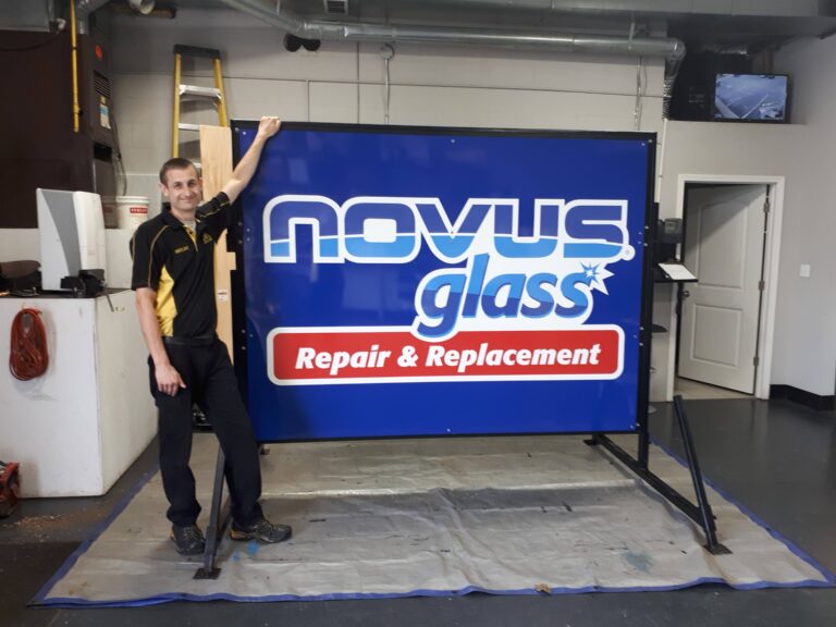 Shelby with the new NOVUS Glass Sarnia Road sign.